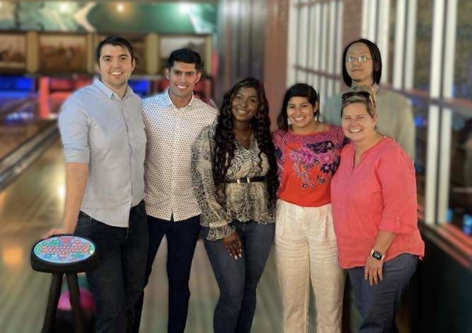 Samuel Castillo collaborating with Expedia Group team during a bowling outing